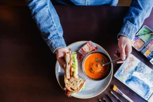 Hudsons lunch special. Person is having a House made tomato soup with a classic BLT sandwich while on break from their job.JOb pictured is an artist.